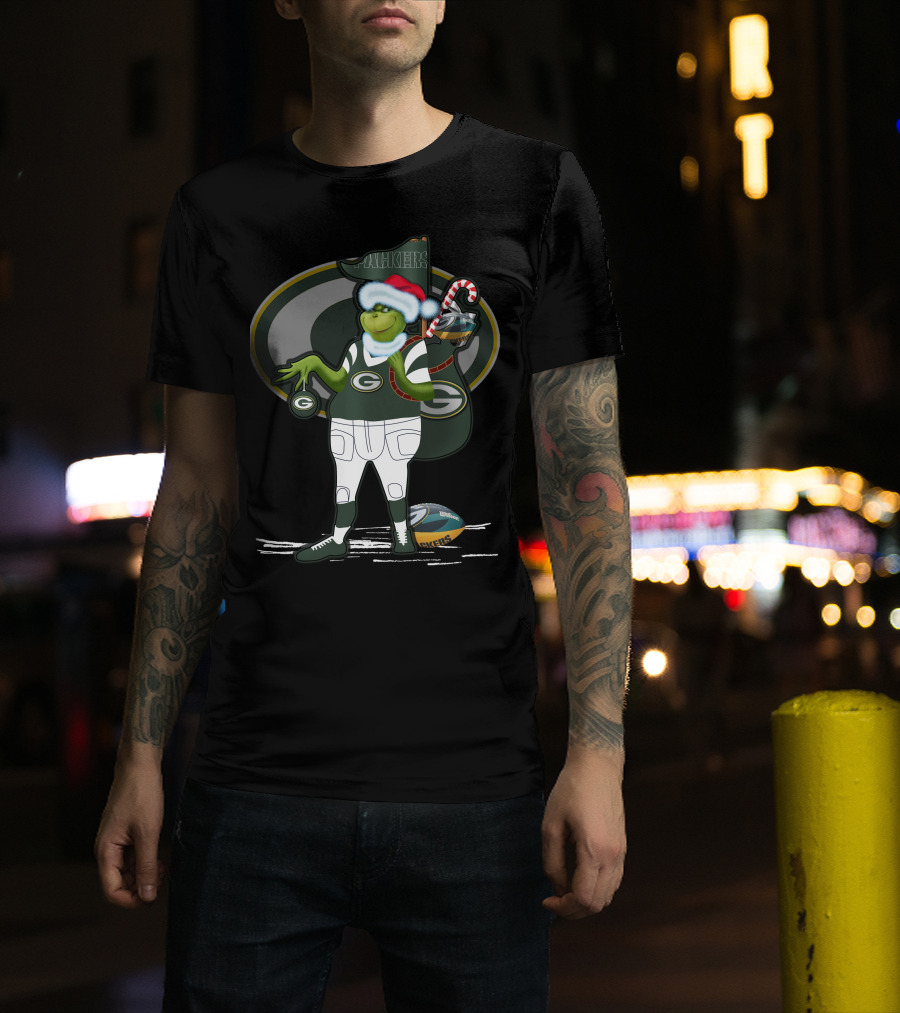 Grinchxmas Green Bay Packers Santa Hat Grinch Holding Helmet And Candy Cane T-Shirt