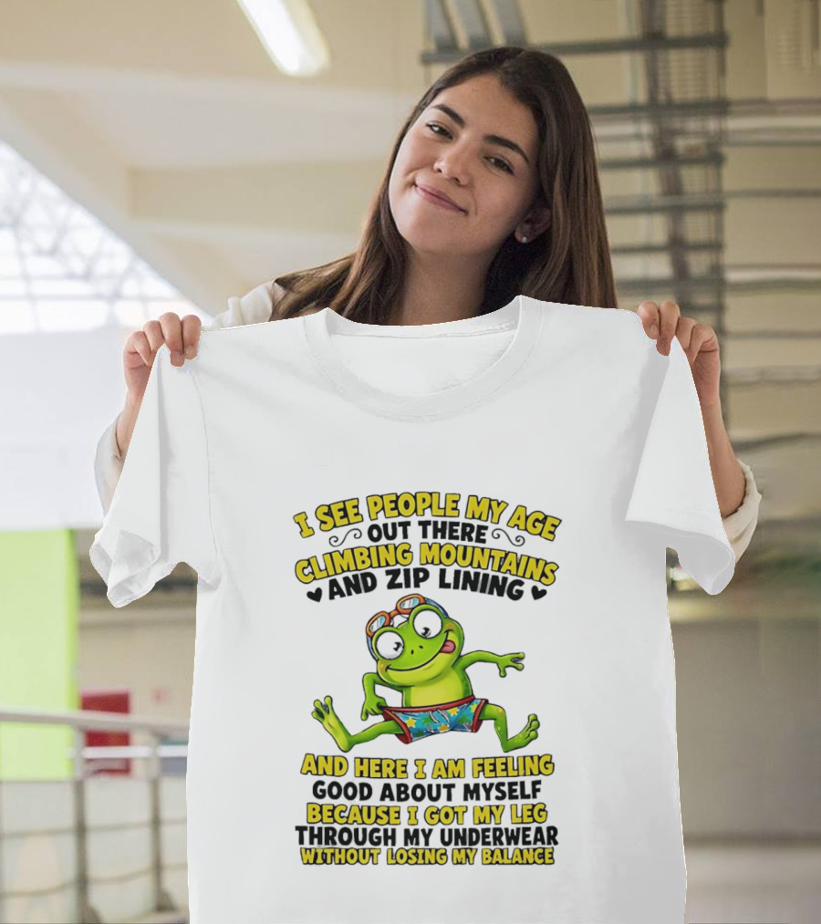 I See People My Age Climbing Mountains And Zip Lining Cartoon Frog Feeling Good Without Losing Balance T-Shirt