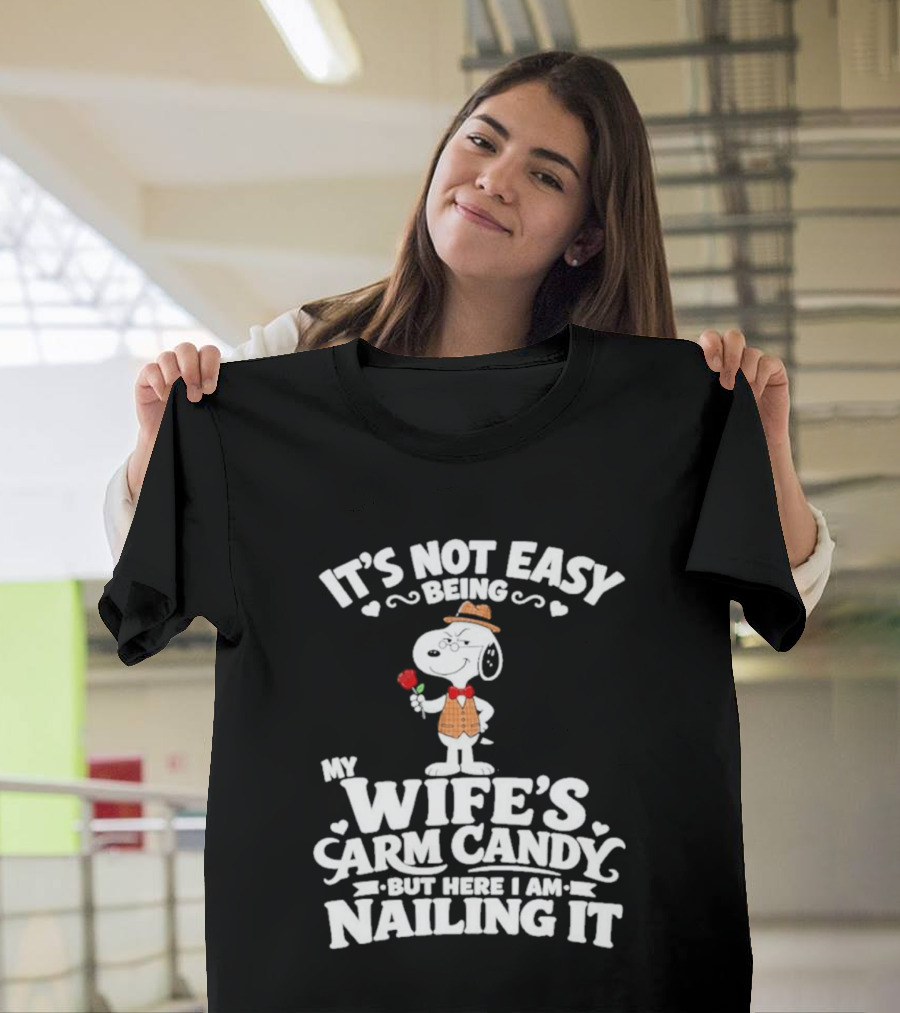 Snoopy It's Not Easy Being My Wife's Arm Candy But Here I Am Nailing It T-Shirt